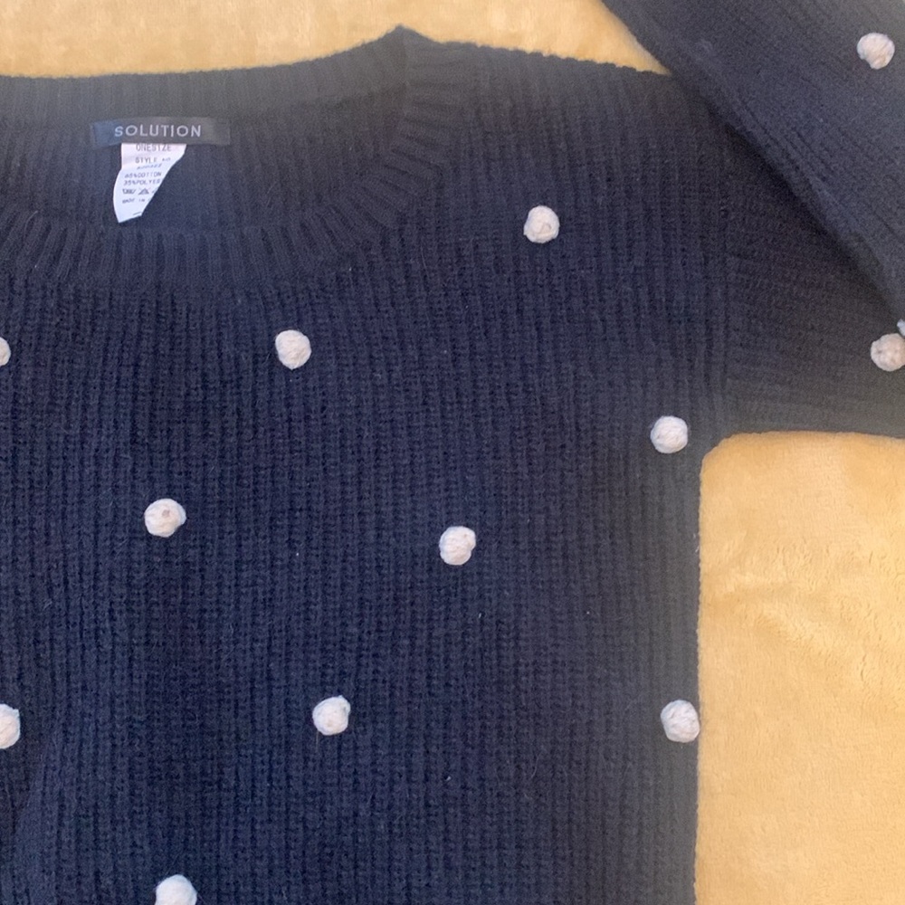 Black sweater with raised white pom poms made by Solutions size Small